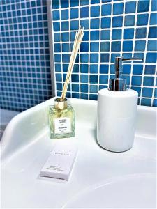 布加勒斯特Arc de Triomphe BlissBoutique的浴室提供一瓶香水和一根棍子