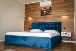 穆里吉奥尔Havana Resort的一间卧室配有一张蓝色的床和木墙