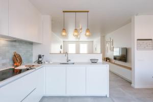 米德尔克尔克Modern house JULIE with spacious garden and garage的白色的厨房配有白色橱柜和水槽