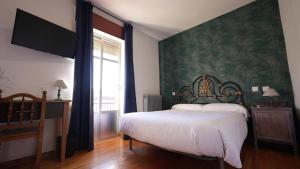 普韦布拉桑纳比亚Hostal La Trucha Sanabria的一间卧室设有一张床和绿色的墙壁