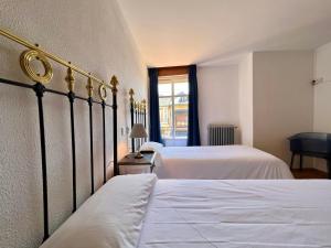 普韦布拉桑纳比亚Hostal La Trucha Sanabria的一间卧室设有两张床和窗户。