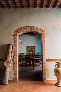 蒙特普齐亚诺Villa Nottola的拱门通往带桌子的用餐室