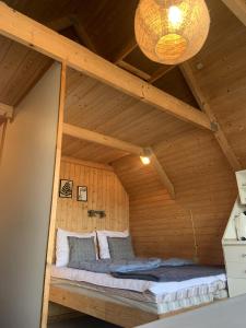 内克瑟Nexø Camping & Cabins的木制客房的一张床位,设有天花板