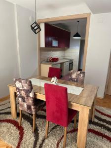 库马诺沃Dada Lux的一张木制餐桌和两张红色椅子