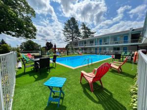 麦基诺城美国精品旅馆 - 湖景的一座带椅子和桌子的游泳池位于一座建筑旁边