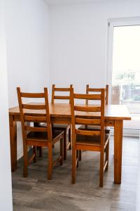 派内Dill Apartments Stederdorf的一张带四把椅子和一张桌子的木桌和一个窗口