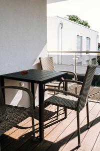 派内Dill Apartments Stederdorf的阳台上配有一张黑色的桌子和椅子