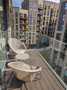 克罗伊登Santina Apartments的阳台配有两把椅子,部分建筑