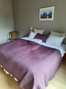 Brekke布克斯塔达弗尔德酒店的一张大床,上面有紫色毯子