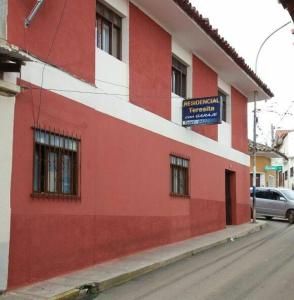 VallegrandeResidencial Teresita的街道边的红白色建筑