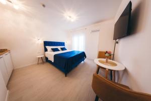 莫斯塔尔Elegant Studio Apartments Lasta的一间卧室配有蓝色的床和电视