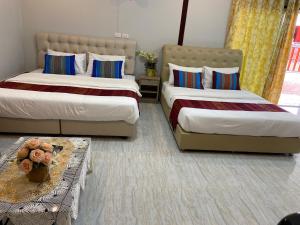 Ban Phayomบุญจินดา รีสอร์ท的一间卧室配有两张床和一张桌子