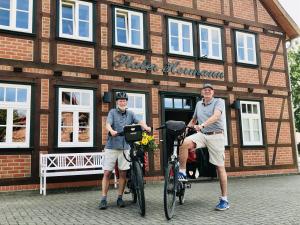 吕肖Plater Hermann的两个人站在一座建筑物前面,骑着自行车