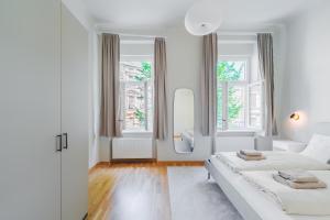 格拉茨Premium apartment - walking distance to city center的一间白色卧室,配有两张床和两个窗户