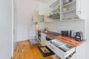 格拉茨Premium apartment - walking distance to city center的厨房配有白色橱柜和木制台面
