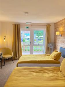 基德明斯特Shenstone Lodge的酒店客房设有两张床和窗户。