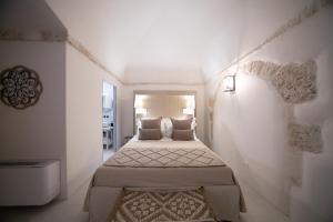 阿尔贝罗贝洛San Marco Boutique Rooms的一间白色的小房间,里面设有两张床