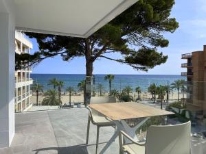 萨洛Rentalmar Suites Salou Families Only的一个带桌椅的庭院和大海