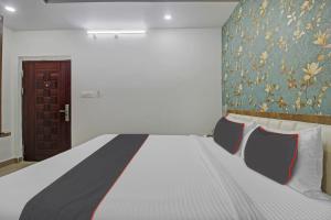 瓦朗加尔Vinayaka Luxury Stays的卧室配有一张床,墙上挂有绘画作品