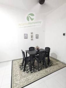 巴东色海MySantai Homestay Padang Serai的一张黑色餐桌,上面有黑色椅子,地毯上