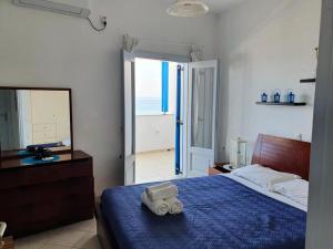 莫诺利索斯Rodothea and Adams on the Beach, Santorini的一间卧室配有一张带蓝色毯子和镜子的床