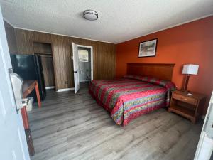 BaxleyPinelodge Motel的一间卧室设有一张床和橙色的墙壁