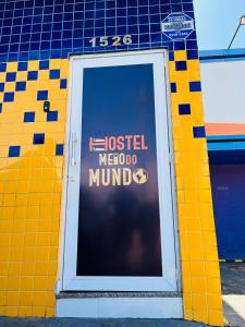马卡帕Hostel Meio do Mundo的大楼上通往旅馆标志的门