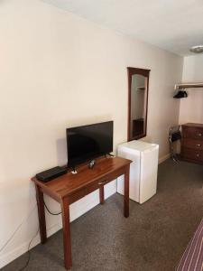 萨里Grantview Inn的客房设有书桌、电视和冰箱。