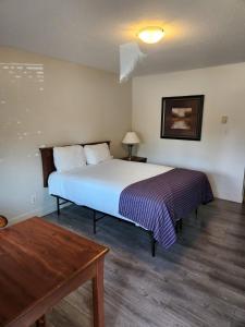 萨里Grantview Inn的一间卧室配有一张大床和一张桌子