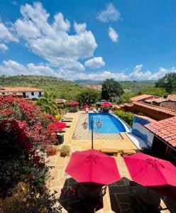 巴里查拉希卡苏阿会议中心酒店的一个带红伞的游泳池和一个度假村