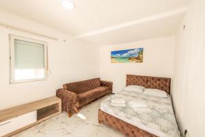 乌尔齐尼Apartmani Medovic的一间卧室配有一张床和一张沙发