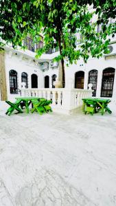 尚勒乌尔法Serce Konagi的两张绿色野餐桌,位于大楼前