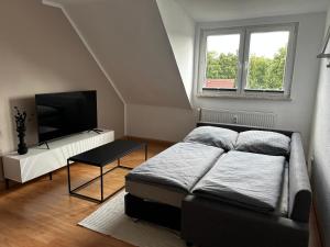 盖尔森基兴Modernes Apartment in Stadionnähe的一间卧室配有一张床和一台平面电视