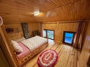 Çaykaraأوزونغول Uzongol Fotinos Wooden Cottage Two Bedroom的木制客房内的一间卧室,配有一张床