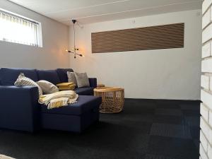 Tølløse120 kvm lejlighed med have i kælderniveau的客厅配有蓝色的沙发和桌子
