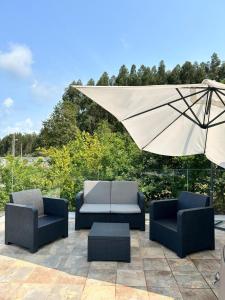 桑亨霍Top Sanxenxo Resort的天井上配有两把椅子和一把遮阳伞