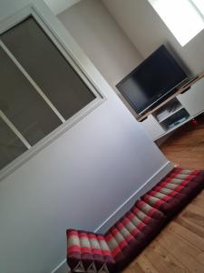 FourChez Lofred 1的带电视的客房内的红色和白色沙发
