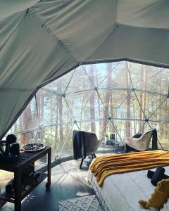 莫雷泰Skywoods.glamping的帐篷内的卧室,配有一张床和一张书桌