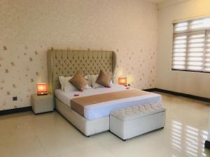康提Royal Retreat Kandy的一间卧室配有一张大床和两盏灯