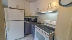 魁北克市Les 300s 3e Avenue的厨房配有白色冰箱和炉灶。
