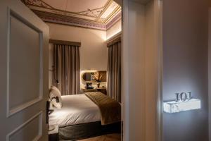 锡蒂亚Palazzo di Sitia Luxury Suites的一间卧室设有一张床和格子天花板