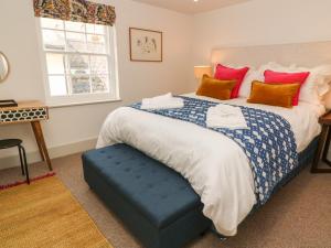 法尔茅斯16 Arwenack Street的一间卧室配有一张大床和蓝色的搁脚凳
