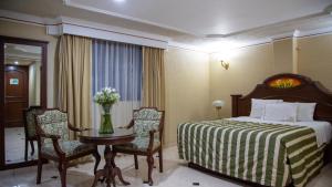 瓜达拉哈拉赌场广场酒店的酒店客房带一张床、一张桌子和椅子