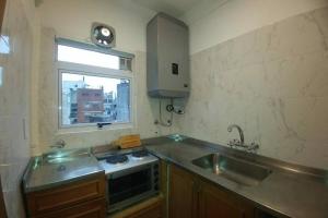 布宜诺斯艾利斯Monoambiente Palermo temporario的一个带水槽和窗户的小厨房