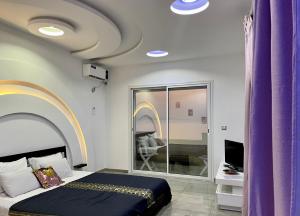 Al MatlīnMaster Suite in Bellavista Andalucia with Pool and Beach的一间卧室配有紫色窗帘、一张床和一台电视机