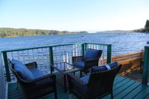 苏克Waterfront Paradise的一个带椅子和桌子的甲板和水