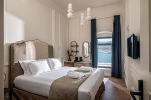 锡蒂亚Palazzo di Sitia Luxury Suites的一间卧室设有一张带电视和窗户的床。