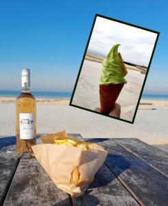 加来Studio plage, vue mer et dragon, garage pour moto的一张冰淇淋锥形和一瓶酒的照片