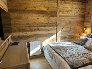 布齐耶比利牛斯2000Le cerf majestueux, Bolquere的一间卧室设有一张床和木墙