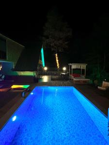 萨潘贾İstanbuldere Bungalov的蓝色的游泳池,晚上带凉亭